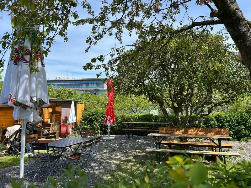 Außenbereich des Gartenstüble mit Tischen unter Bäumen